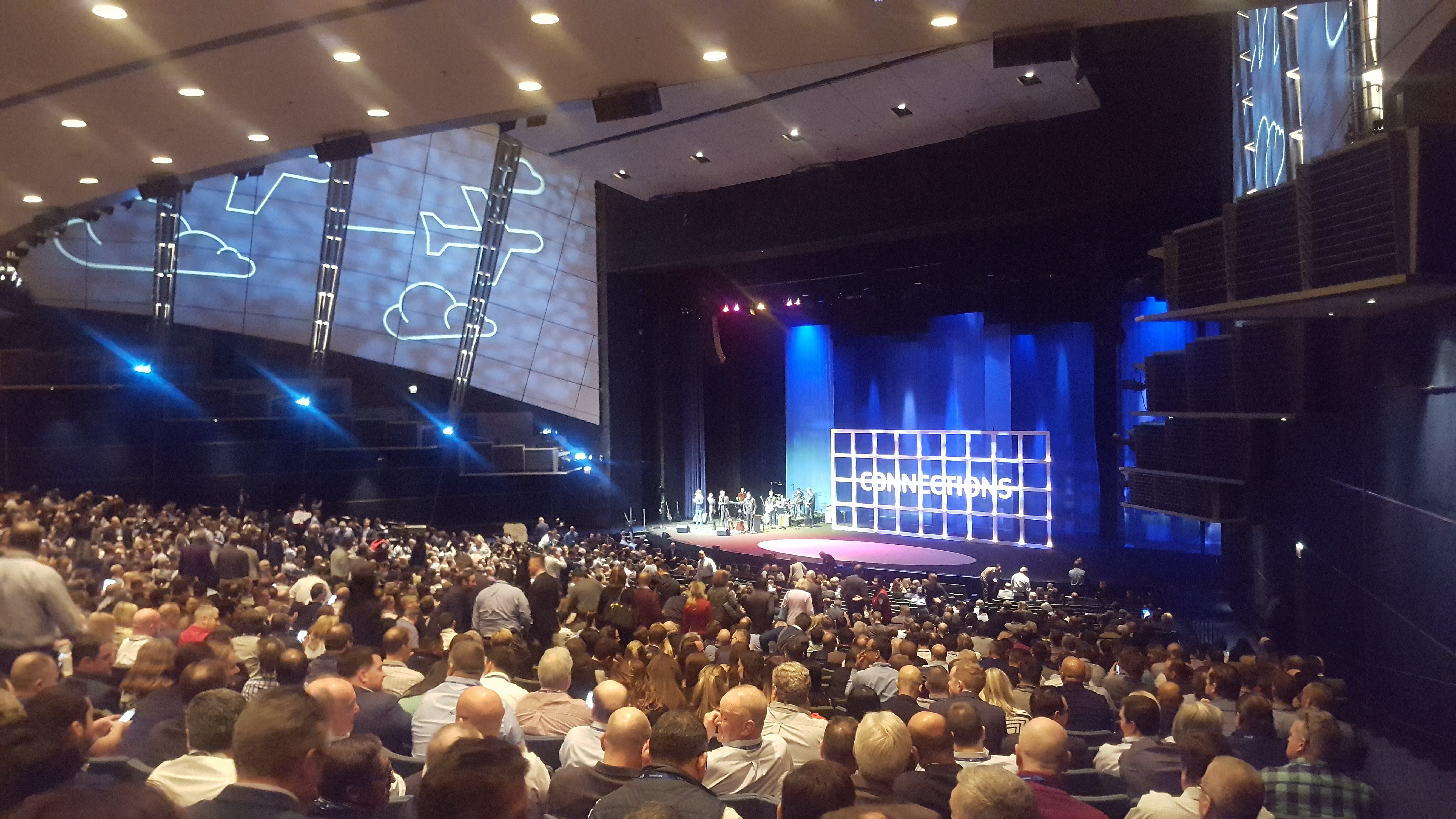 Large crowd in a theater watching a presentation on stage